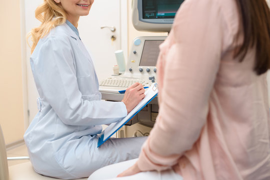 cropped shot of obstetrician gynecologist consulting pregnant woman at ultrasound scanning office