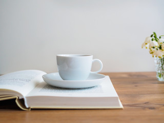 Weise Tasse auf einem offenen Buch