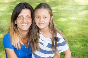 Lifestyle portrait mother and daughter in happiness outside in the meadow garden home