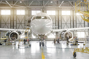 Passenger aircraft on maintenance of engine-disassembled engine blades and fuselage repair in airport hangar.