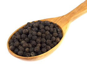 Black pepper peas on a wooden spoon  on a white background
