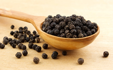 Black pepper peas on a wooden spoon  on a wooden table