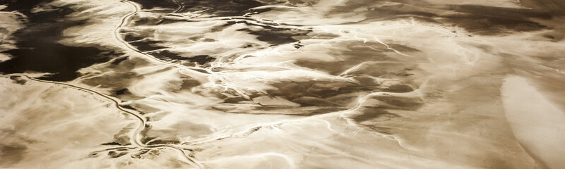 Beautiful abstract landscape image taken from airplane window above the Salar de Uyuni during sunrise