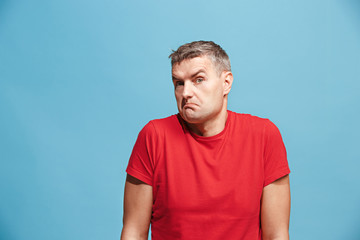Obraz premium Suspiciont. Doubtful pensive man with thoughtful expression making choice against blue background