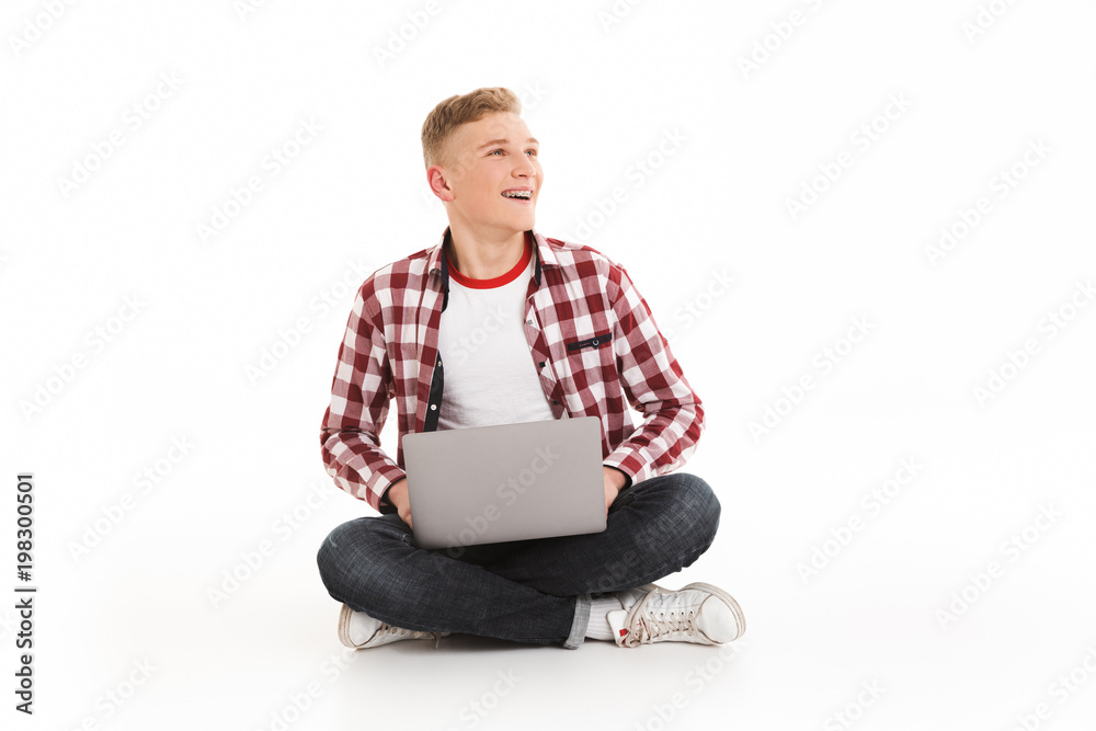 Sticker smiling young guy using laptop computer