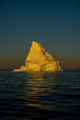 Fototapeta na wymiar Sunrise in Greenland. Iceberg in sun light. 