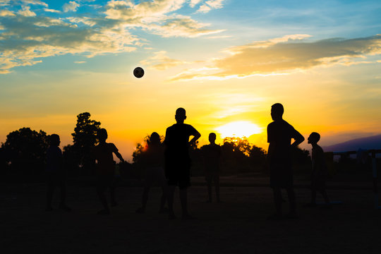 An action picture of a group of kids playing soccer football for exercise.