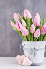 Spring easter tulips in bucket on white vintage background.