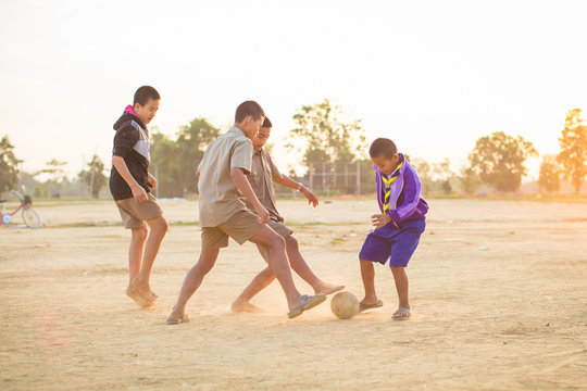 An action picture of a group of kids playing soccer football for exercise.