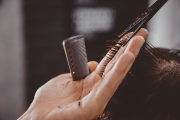 Naklejka premium Barbershop. Close-up of man haircut, master does the hair styling in barber shop
