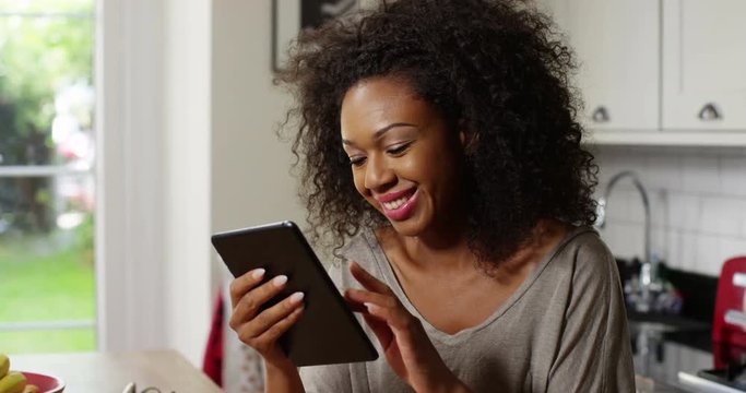 Attractive young woman using a digital tablet at home.