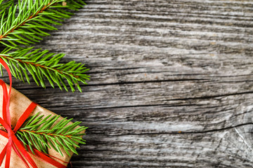 Christmas gift box, wrapped present in rustic package on wooden background