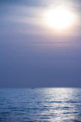 Obraz premium fisherman boat in calm sea at sunrise in the morning