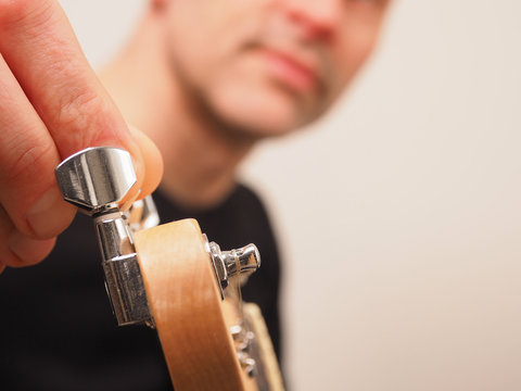 Musiker stimmt seine Gitarre, selektiver Fokus auf die Stimmmechanik