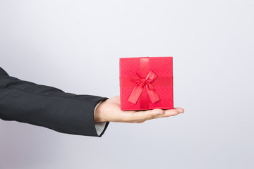 Businessman holds out the gift red box, isolated background