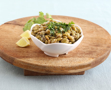 Avarekai palya or hyacinth beans curry, a home cooked south Indian vegetarian side dish, in a bowl on a wooden table.