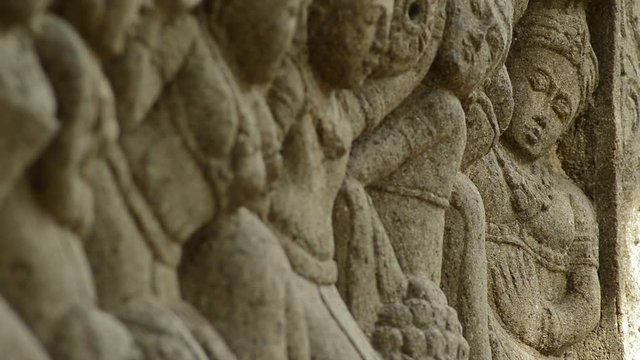Different figures of an archaeological asiatic monument in a mural stone