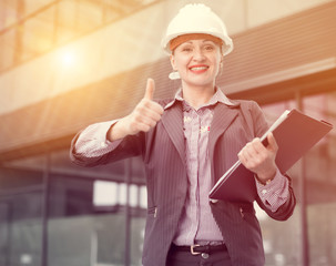 Employee woman in helmet with paper documents