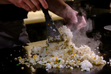 Hands of Chef cooking garlic fried rice on hot pan in the restaurants