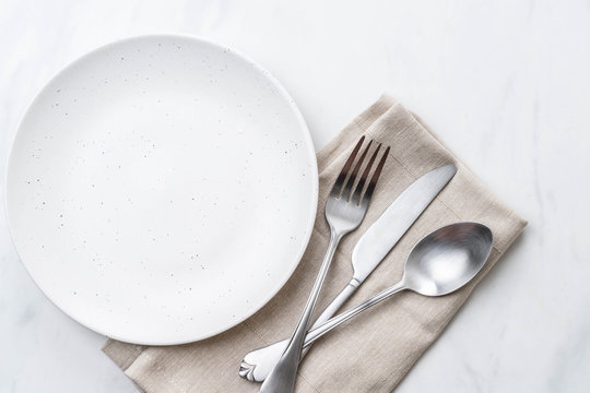 empty plate spoon fork and knife