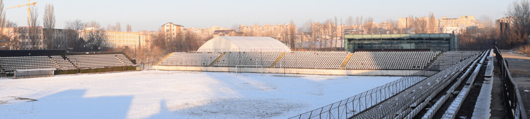 Fototapeta premium Bucharest, Sportul Studentesc stadium in the winter. Panorama of empty stadium covered in snow.
