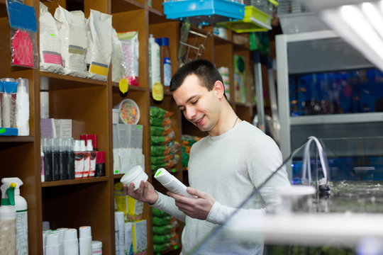 Young Man With Pet Supplements In Petshop