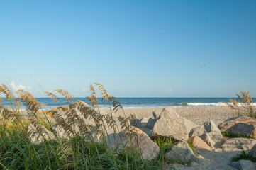 The beach with rocks and sea oats in the foreground