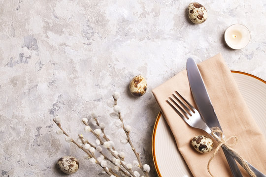 Easter Table Setting Composition: Quail Eggs, Candle, Wilflowers, Pussy Willow On Plate W/ Napkin, White Stucco Plaster Texture Background. Close Up, Top View, Copy Space, Greeting, Template.