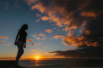 Silhouette of a girl standing in sunset