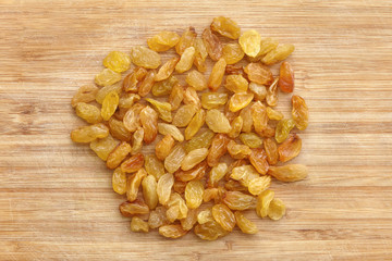 Heap of raisins, dried grapes on wooden background