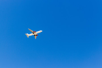 Fototapeta na wymiar A plane flying in the blue sky without white clouds