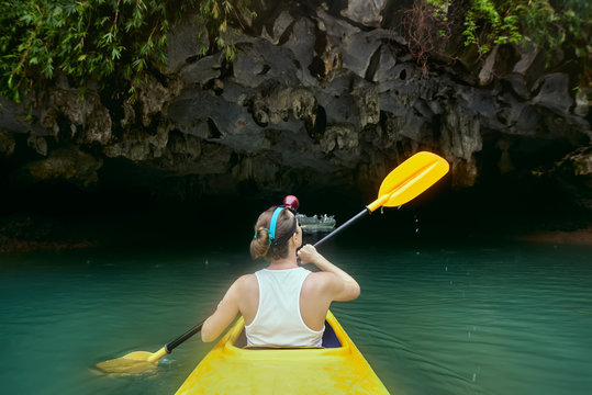 Woman paddling the kayak enjoying at the view karst cave