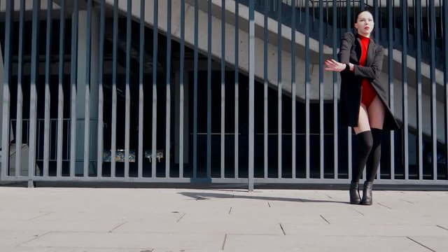 Sexy female dancer in Vogue and Waacking dance style dancing in the city with urban background.