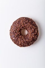 Glazed chocolate donut with sweet chocolate sprinkles on white background