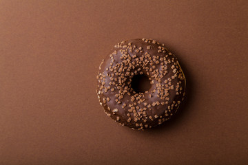 Chocolate donuts on brown background. Monochromatic concept.