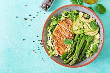 Chicken fillet cooked on a grill with a garnish of asparagus and grilled avokado. Dietary menu. Healthy food. Flat lay. Top view