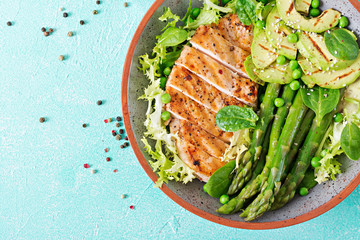 Chicken fillet cooked on a grill with a garnish of asparagus and grilled avokado. Dietary menu. Healthy food. Flat lay. Top view