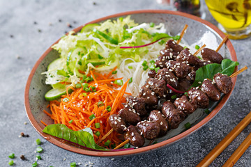 Chicken hearts in spicy sauce, noodles and vegetable salad. Healthy food.