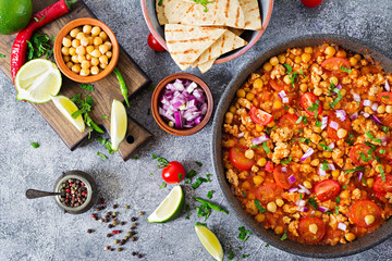 Chili con carne of turkey  with chickpeas served with nachos.  Chili with meat, nachos, lime, hot pepper. Mexican / Texas traditional food.