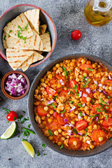 Chili con carne of turkey  with chickpeas served with nachos.  Chili with meat, nachos, lime, hot pepper. Mexican / Texas traditional food.