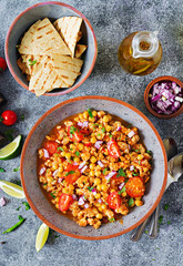 Chili con carne of turkey  with chickpeas served with nachos.  Chili with meat, nachos, lime, hot pepper. Mexican / Texas traditional food.