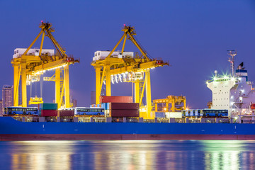 Obraz premium Shipping working loading containers by crane in ship on the night