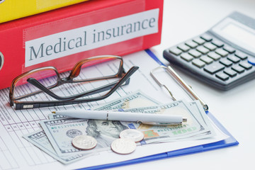 Clean insurance form, pen, glasses and money