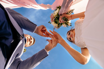 The bride and groom are exchanging wedding rings.