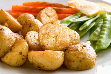 young potato in jackets fried with herbs, salmon, sweet pea pods 