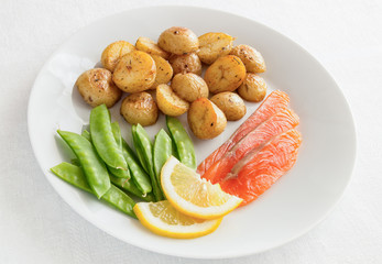 freshly salted fish slices, fried potatoes in jackets and sweet pea pods