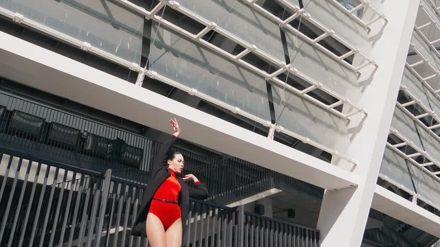 Sexy female dancer in Vogue and Waacking dance style dancing in the city with urban background.