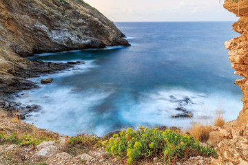 Sea bay with steep, rocky shores shot on long exposure.