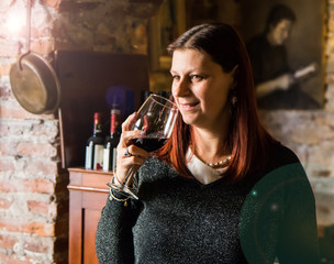 beautiful woman drinking glass of wina in a wine cellar