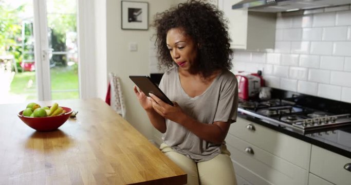 Dolly shot of a young woman using tablet for online shopping. Working from home